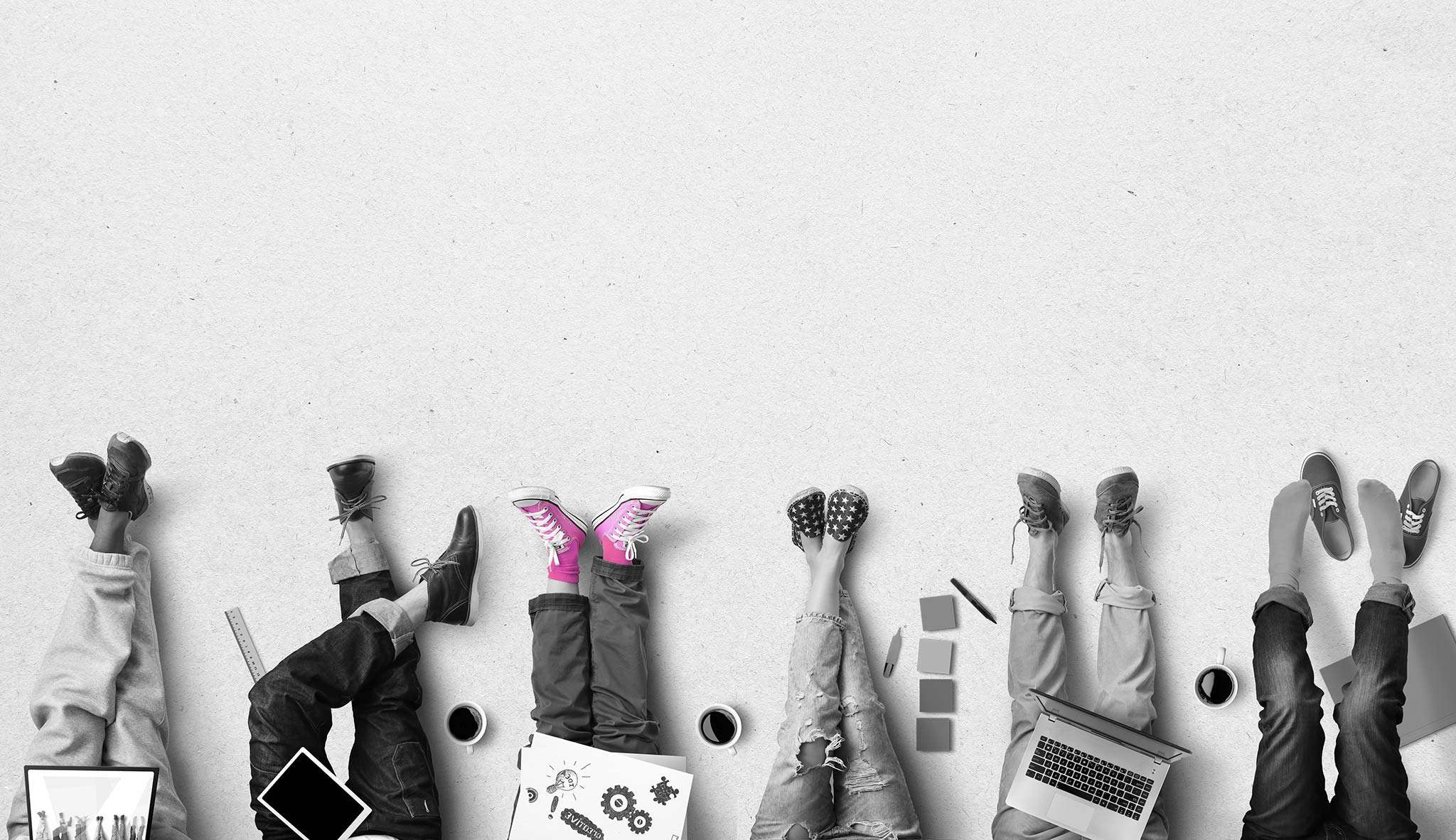 Black and white photo of people working on their ground with their feet sticking out, one of them wearing pink shoes
